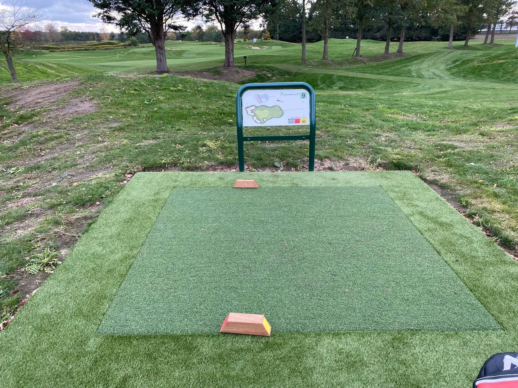 Artificial turf tee box with tee markers
