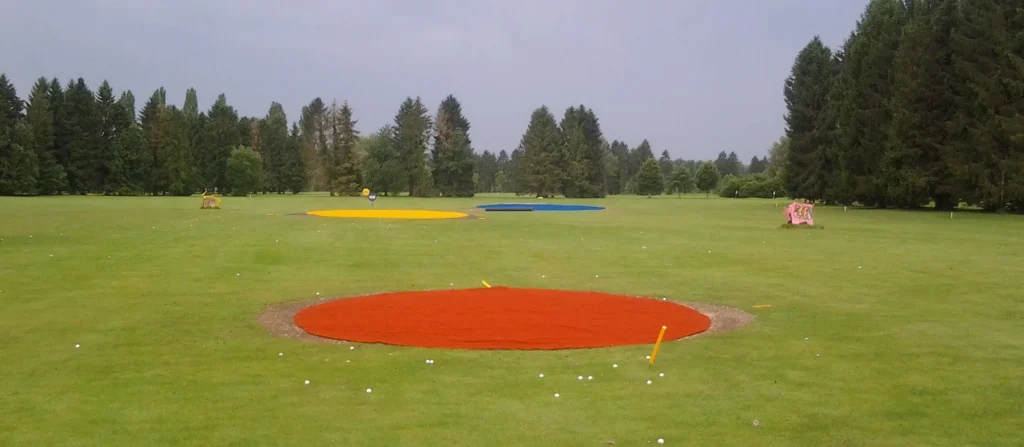Red, yellow and blue artificial turf targets on a driving range