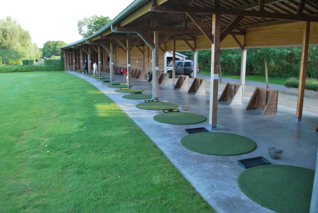 Round driving range mats under a covered hitting area